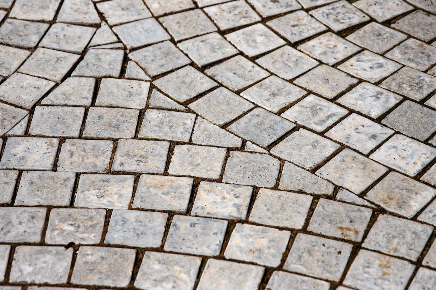 Weathered cobblestone pavers set in a curved fan pattern, shown up close
